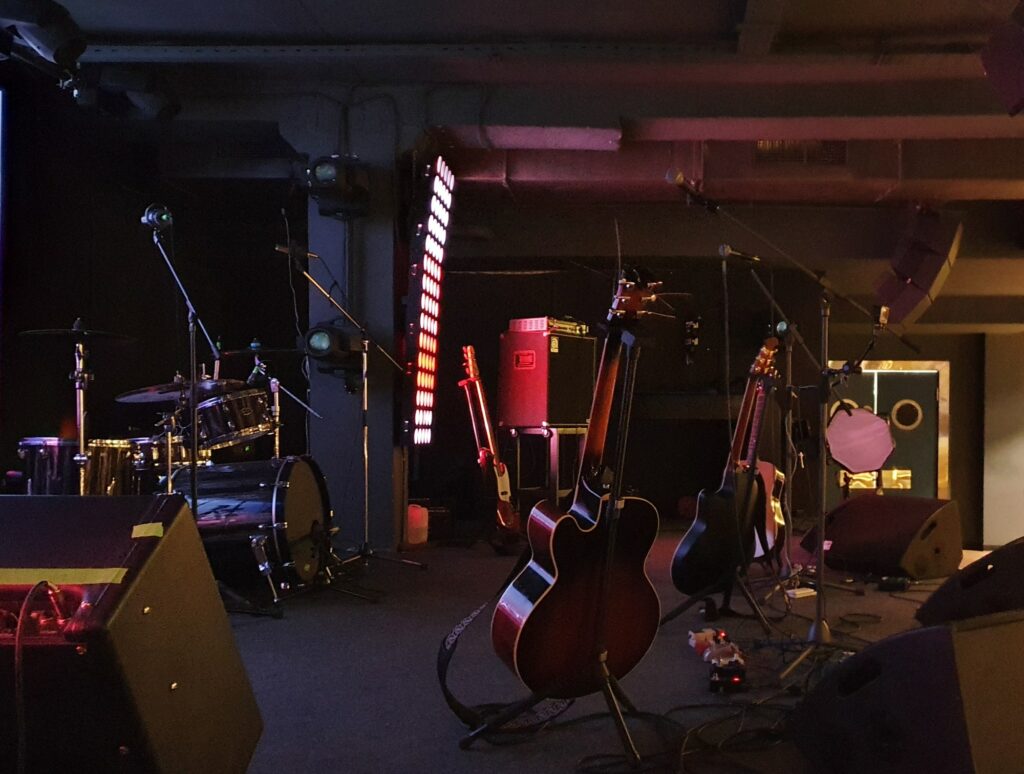 Stage with musical instruments and lighting in a nightclub before a concert.